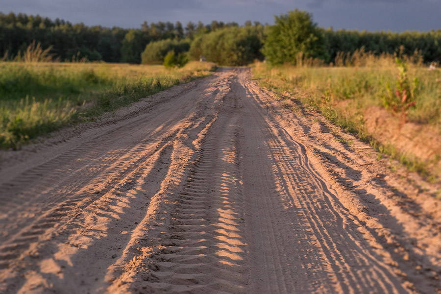 piaszczysta droga ze sladami traktorów