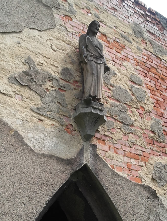 na zdjeciu figura Jezusa Chrystusa na tle ceglanego muru