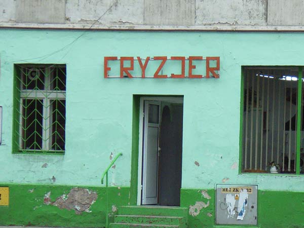 czerwony napis Fryzjer na zielonej ścianie 